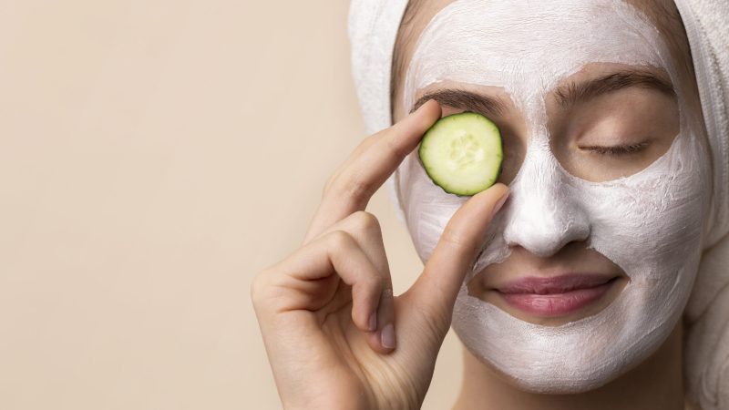 front view girl holding cucumber slice